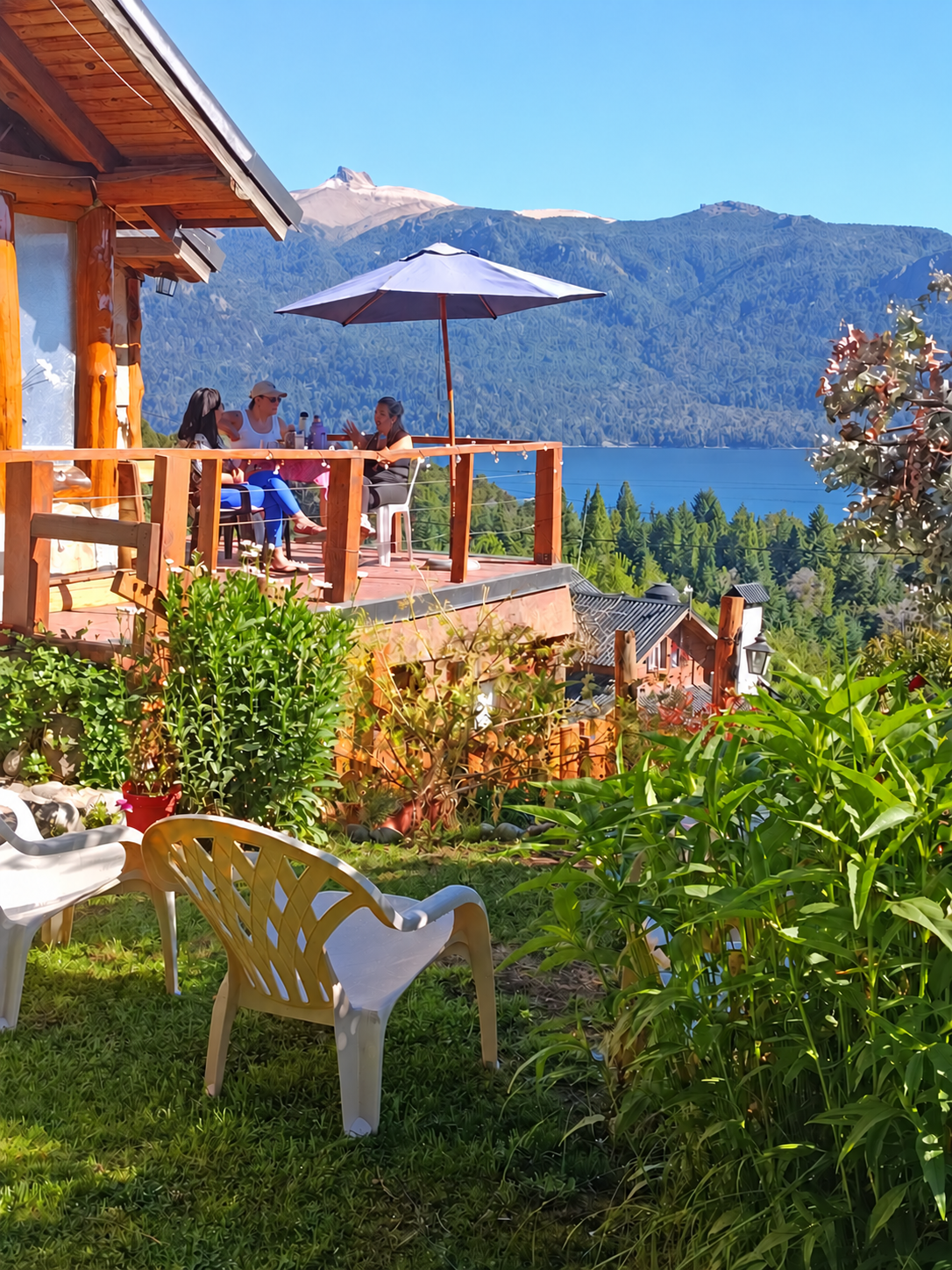 Mujeres compartiendo naturalmente en el balcón de La Soñada frente al lago Traful